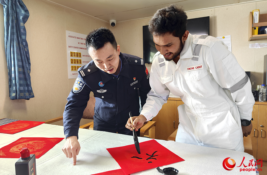 外籍船員在邊檢民警的帶領下寫下“福”字。人民網記者 孫一凡攝