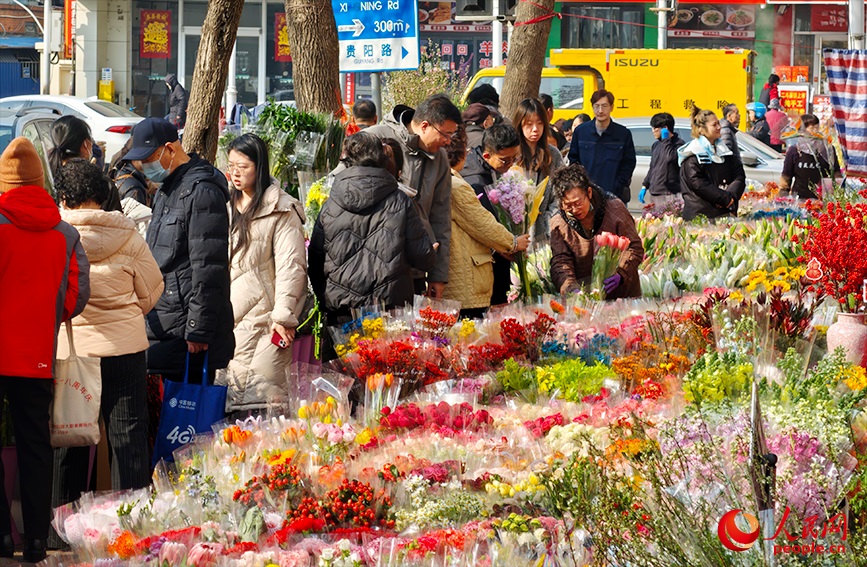 街边摊位人头攒动，市民忙着挑选花束。人民网记者 孙一凡摄
