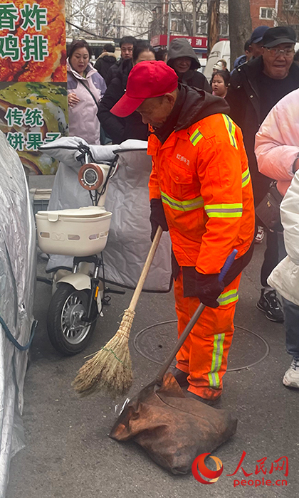 李春和工友们及时清扫垃圾，确保街区整洁有序。人民网记者 唐心怡摄