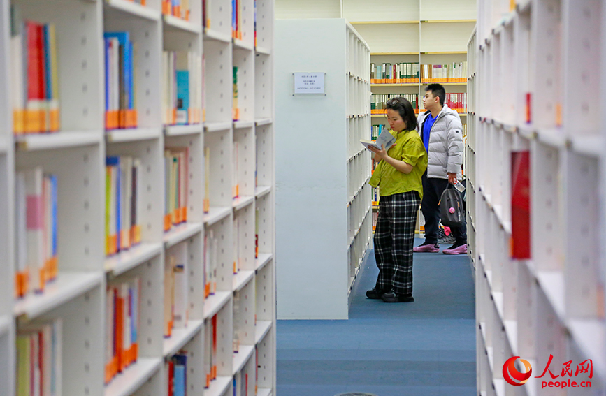 读者在书架间静心阅读，品味书香年味。人民网记者 崔新耀摄