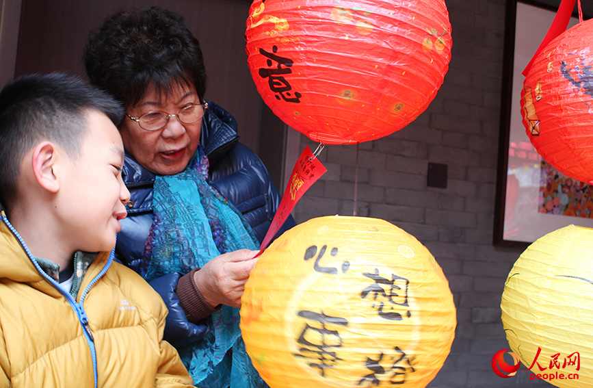 家长和孩子一起猜灯谜。人民网记者 张静淇摄