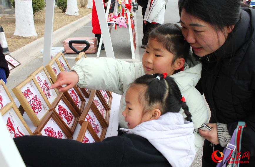 孩子们被市集上的剪纸作品吸引。人民网记者 张静淇摄