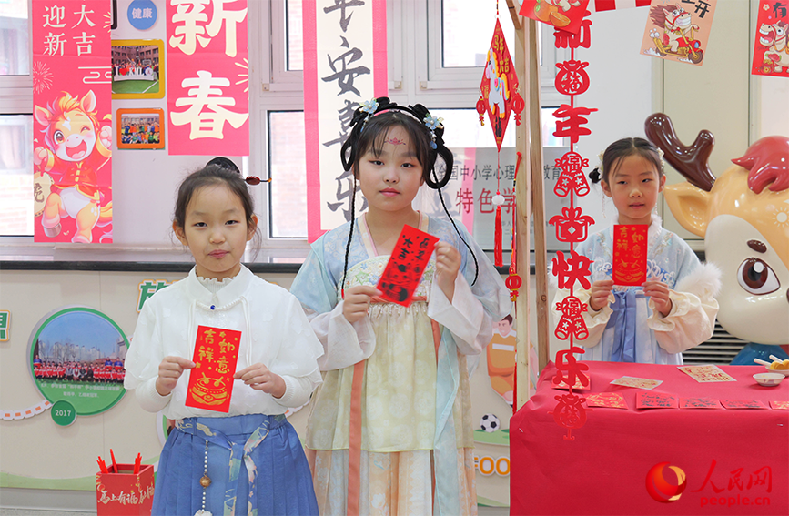 非遗拓福区，学生们与拓印作品合影留念。人民网记者 郭维瑾摄