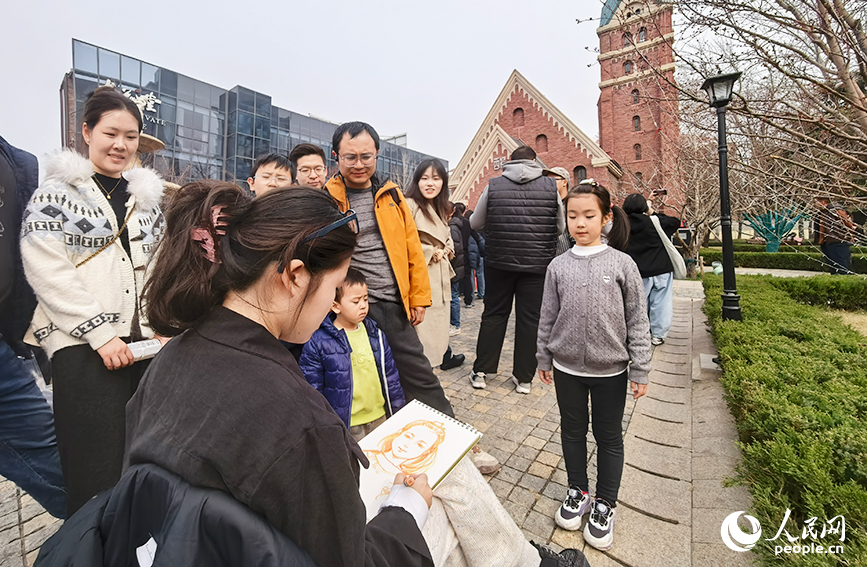天津美术学院学生现场为市民游客绘制肖像画。人民网记者 陶建摄