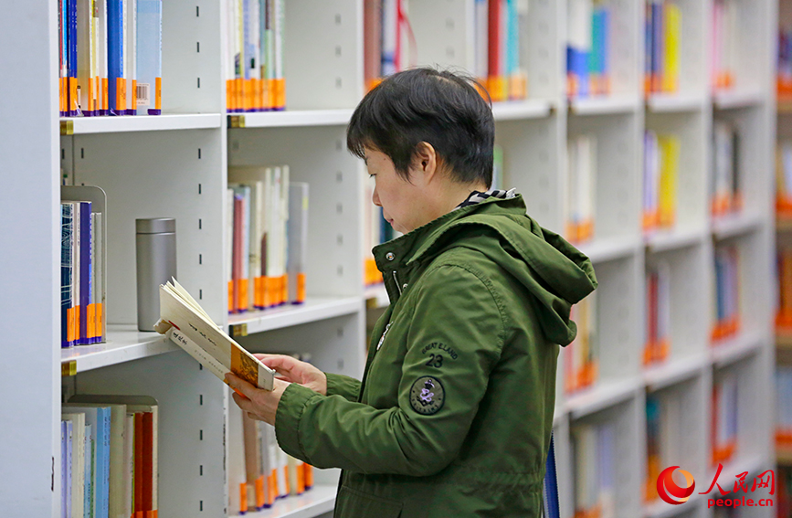 读者驻足书架前静静翻阅，沉浸书中。人民网记者 崔新耀摄