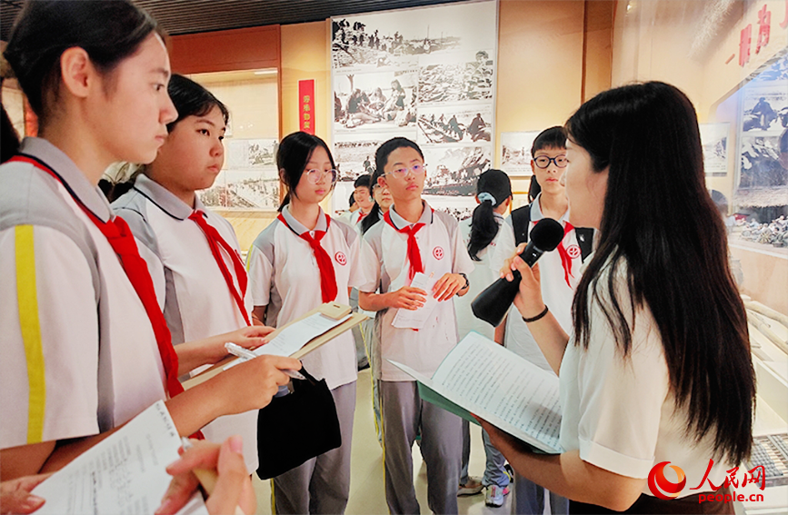 思政教师担任讲解员，将展柜里的革命文物与课程知识巧妙结合。人民网记者 郭维瑾摄