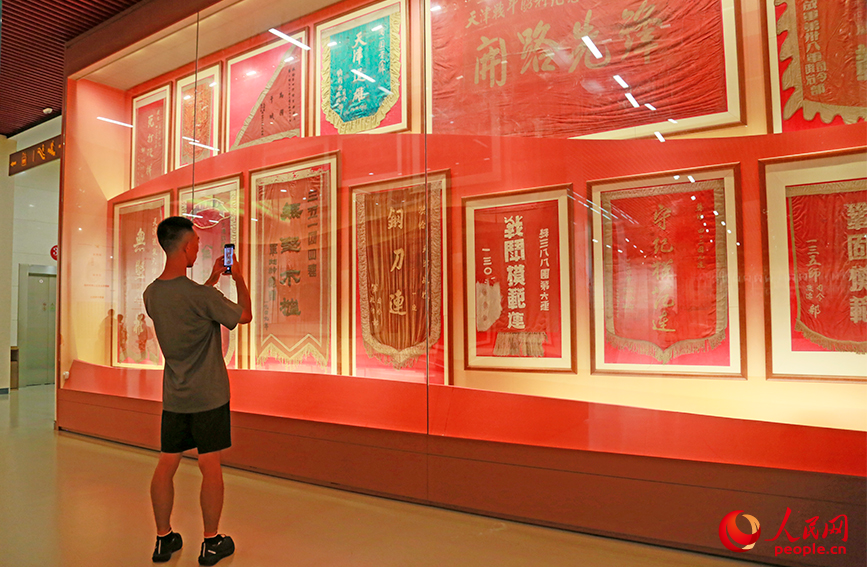 观众在荣誉称号锦旗前驻足拍照。实习生 杨浚艺摄