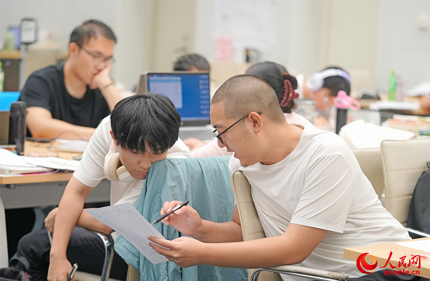 自习室内，两位读者正在轻声讨论课业难题。实习生 耿嘉阳摄