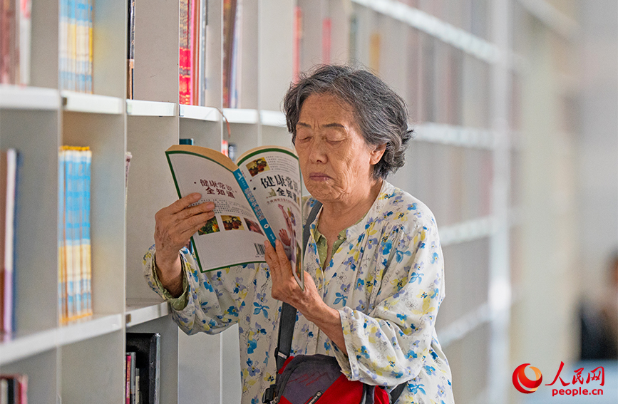 一位读者正沉浸在书海中，神情专注。实习生 杨浚艺摄