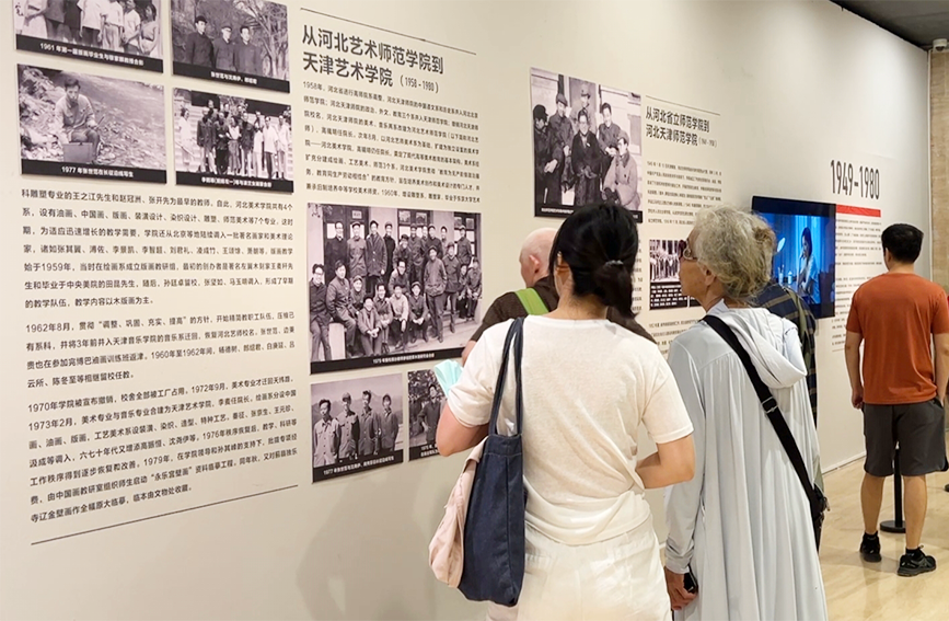 观众在展板前了解天美百廿发展历史。天津美术学院供图