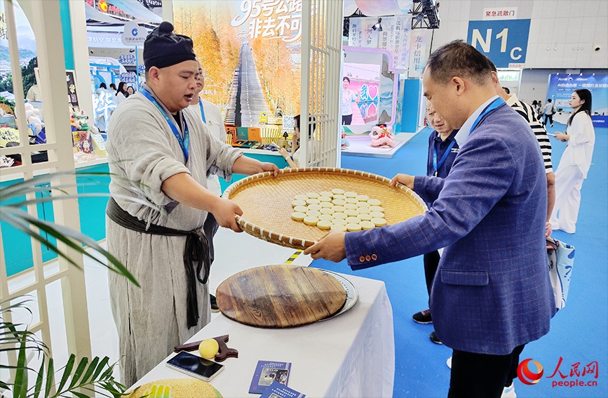 观众向NPC学习麻饼制作技艺。人民网记者 郭维瑾摄