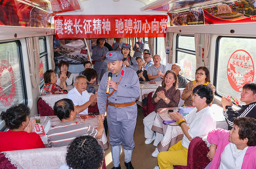 10月15日,乘务人员穿着红军服饰为旅客唱红歌。杨宝森摄